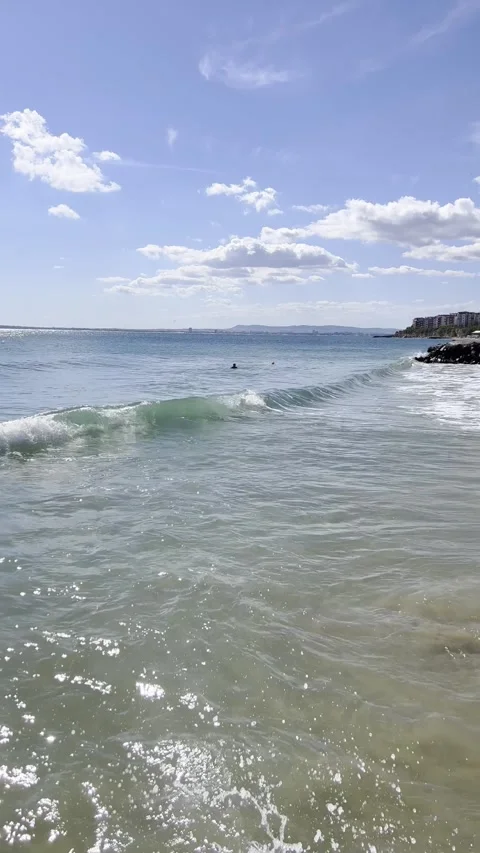 Gentle Waves on a Sunny Beach with Clear Blue Sky Stock Footage 318713769