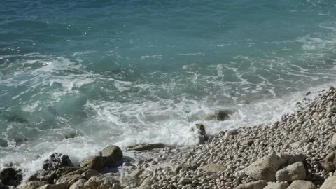 Gentle Waves Wash Onto A Warm Pebble Beach HD Background Stock Footage 101889773