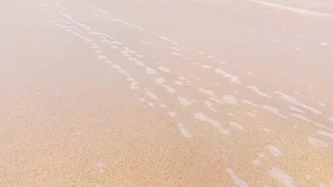 Gentle waves washing onto a sandy beach Stock Footage 346335917