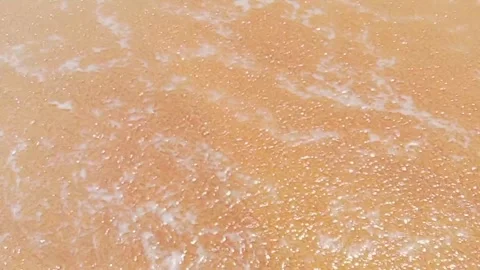 Gentle waves washing onto a sandy beach Stock Footage 346335922