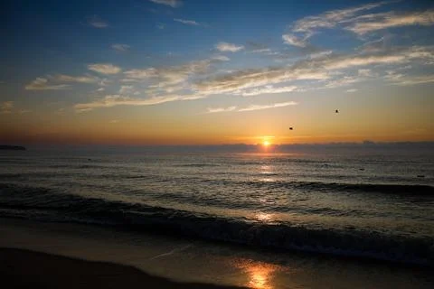 Gentle waves while the sun is rising over the Black Sea in the Obzor resort i Stock Photos