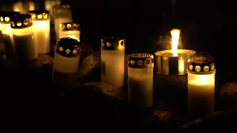 Gentle wind caressing cemetery grave candles in the night Stock Footage 289048588
