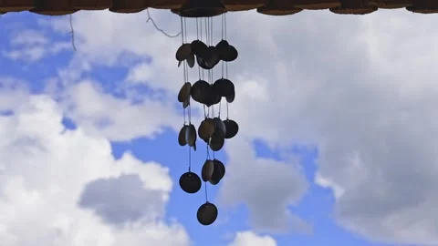 Gentle Wind Chimes Dancing Under a Bright Afternoon Sky Near Home Stock Footage 344237964