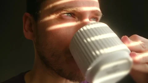 Gentleman absorbs morning light while holding his coffee cup peacefully Stock Footage 337546782