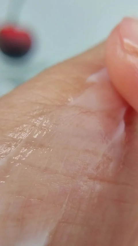 Gently applying white cream thoroughly all over the palm, close up view Stock Footage 330027323