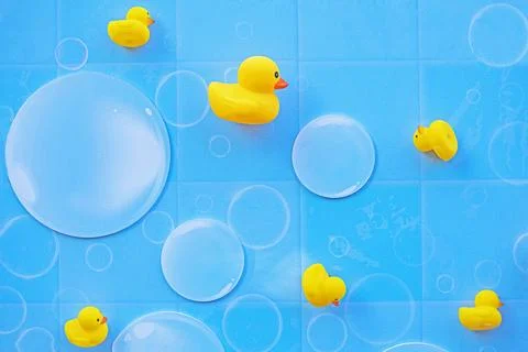 Gently blue background with tiny bubbles and yellow ducks Stock Photos
