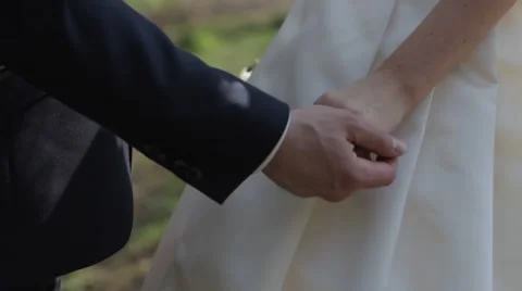 Gently connected hands of a newly-married couple with wedding rings on a finger Stock Footage 50014116