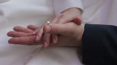 Gently connected hands of a newly-married couple with wedding rings on a finger Stock Footage 50014237