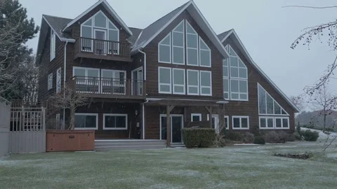 Gently falling snow in front of chalet style house Stock Footage 77280872