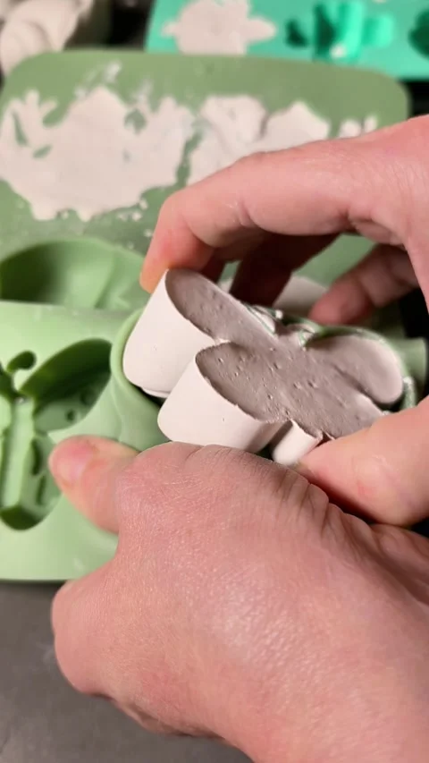 Gently lifting plaster figure from mold, crafted shape with visible texture, Stock Footage 344550547