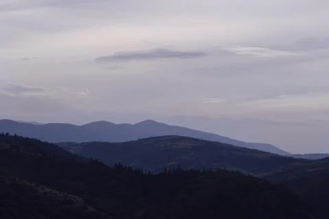 Gently pink sunset with the setting sun behind the mountains Stock Photos