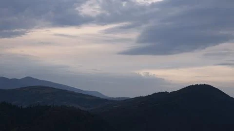 Gently pink sunset with the setting sun behind the mountains. Stock Photos