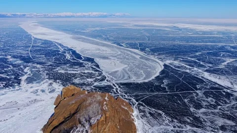 Gently Pulling Away from Cape Khoboy Over Cracked Lake Baikal Stock Footage 342235859