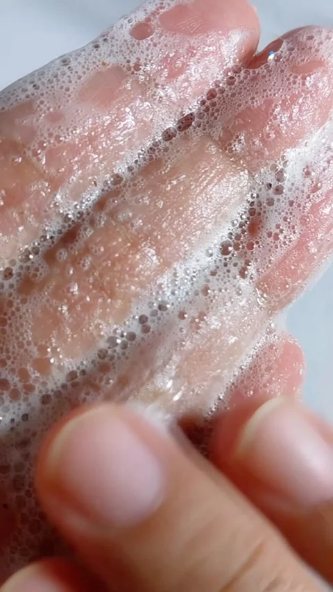 Gently rubbing soap foam bubbles on wet palm of hand. Close up view showing.. Vídeo Stock 335022622