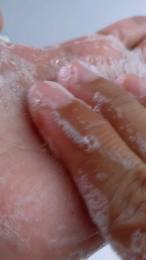 Gently rubbing soap on palm of hand. Close up view showing wet skin texture.. Vídeo Stock 335022602