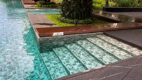 A gently sloping entryway into a modern condominium pool in Thailand after rain. Stock Photos