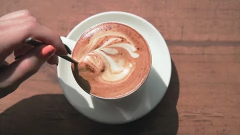 Gently stirring freshly brewed coffee with a spoon in a white saucer cup. Video stock 234020741