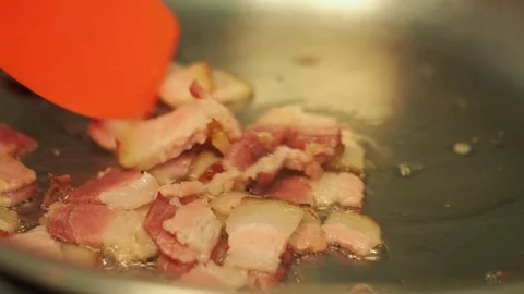 Gently stirring frying bacon cubes Stock-Footage 128001649