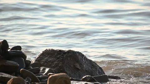 Gently waves hitting rocky shore on bright sunny day Stock Footage 138264201