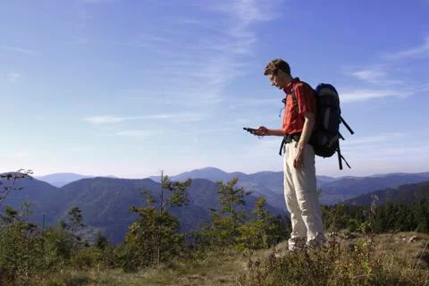 Geocacher checking the coordinates with a gps navigation system on mt. leder  Stock Photos