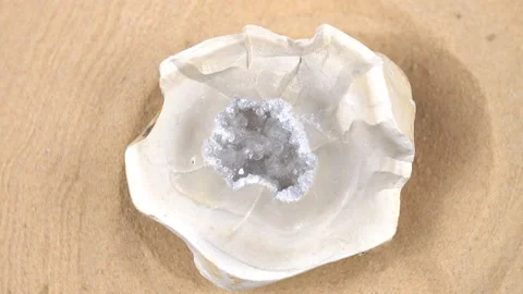 Geode rock crystal is rotating against the sand background Stock Footage 203891741