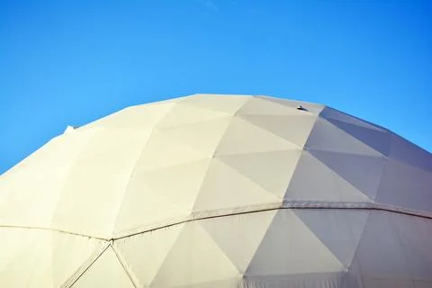 Geodesic dome on a background of blue sky 스톡 사진