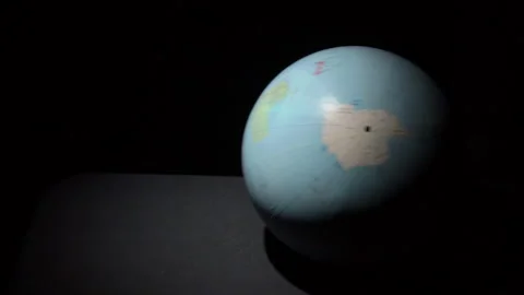 Geographic Globe Rolls on a Black Surface in Slowmo Stock Footage 170906119