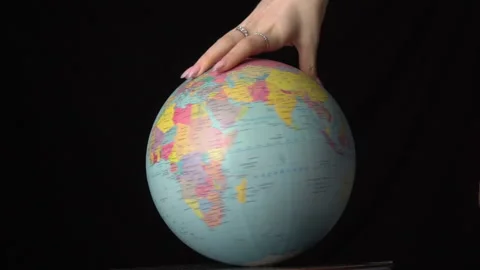 Geographical Globe is Twisted Around its Axis by a Female Hand Stock Footage 170906001