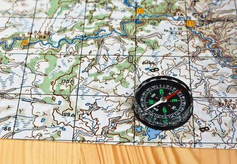 Geographical map and a compass. Stock Photos