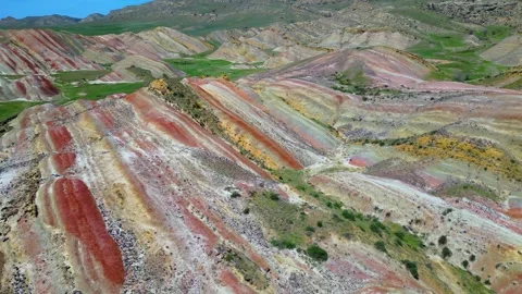 Geological pattern with maroon, yellow and white stripes among the mountains Stock Footage 278612325