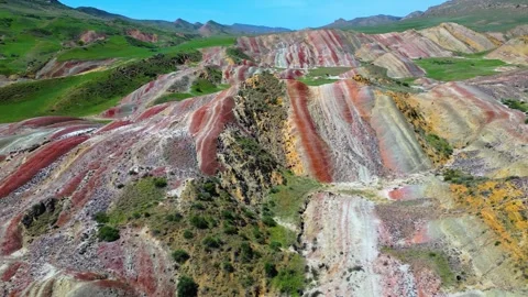 Geological pattern with maroon, yellow and white stripes among the mountains Stock Footage 278612346