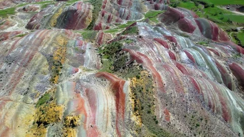 Geological pattern with maroon, yellow and white stripes among the mountains Stock Footage 278612386