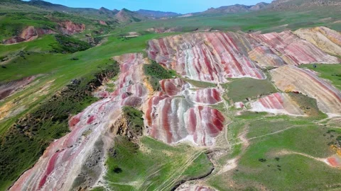 Geological pattern with maroon, yellow and white stripes among the mountains Stock Footage 278612431