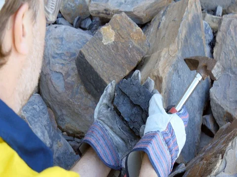 Geologist braking coal sample with pick axe mining exploration  Stock Footage 78588183