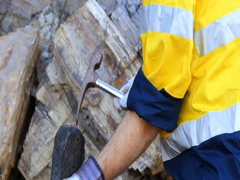 Geologist braking coal sample with pick axe mining mineral exploration  Stock Footage 78590009