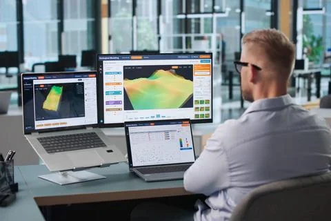 Geologist Studies 3D Subsurface Data Using Laptop For Reservoir Analysis. Stock Photos