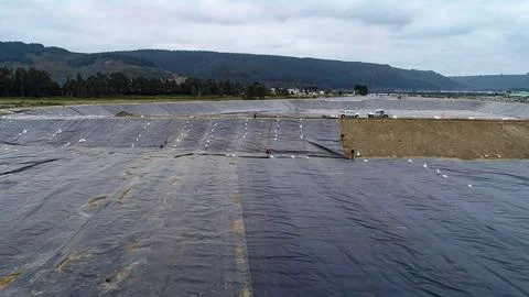 Geomembrane deployment and installation process with machinery in the const.. Stock Photos