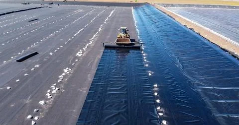 Geomembrane deployment and installation process with machinery in the const.. Stock Photos