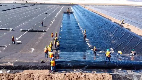 Geomembrane deployment and installation process with machinery in the const.. Stock Photos