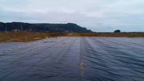 Geomembrane deployment and installation process with machinery in the const.. Stock Photos