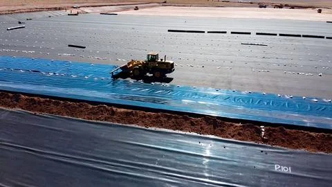 Geomembrane deployment and installation process with machinery in the const.. Stock Photos
