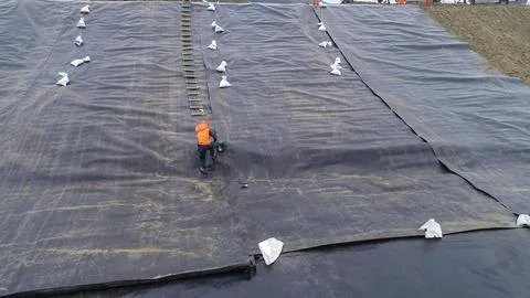 Geomembrane deployment and installation process with machinery in the const.. Stock Photos