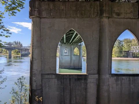 Geometric bridge supports frame a view beneath a river crossings Stock Photos