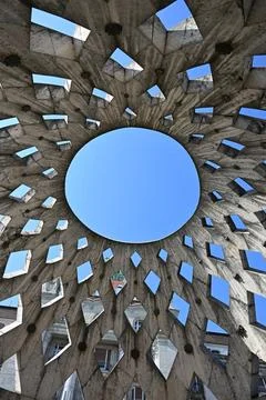 Geometric concrete dome structure with circular opening against blue sky Stock Photos