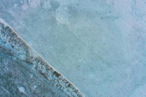 Geometric division line between snow cover and dry grass field, contrast winter Stock Photos