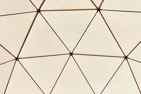 Geometric dome framework repeating across warm minimal interior ceiling Stock Photos