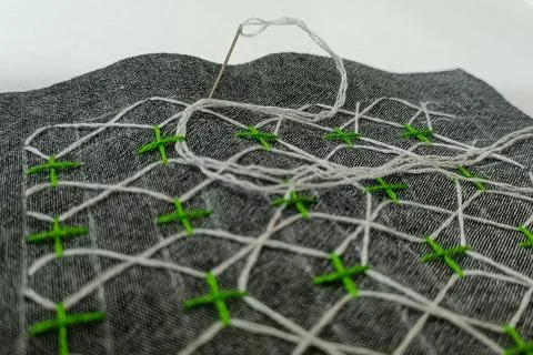 Geometric Hand Embroidery Pattern with White and Green Threads Macro Fotos de archivo