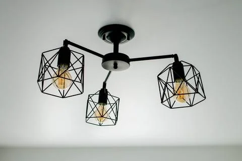 Geometric lamp hangs on a white ceiling. Modern, minimalist lamp that success Foto stock
