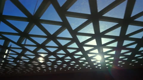 Geometric lattice roof pattern framing sunlight and blue sky, highlighting .. Stock Footage 314607935