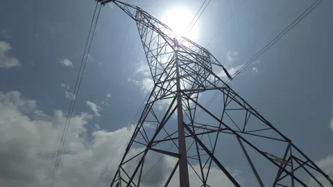 A geometric lattice tower vaults into the sun, anchoring a grid fueling industri Stock Footage 340514693
